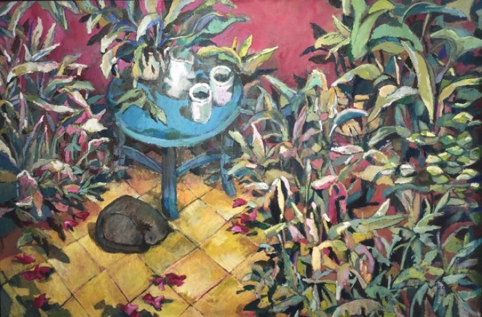 Jardín con mesita azul y gato